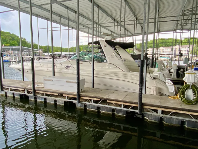 Slide: The Image of 1999 Sea Ray 400 Sundancer docked in a marina under a covered structure. - 2
