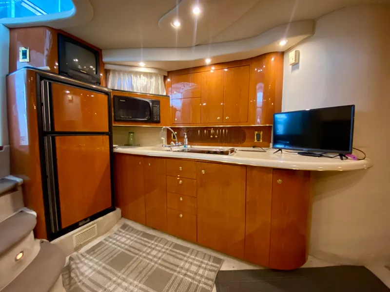 Slide: The Image of Luxurious 1999 Sea Ray 400 Sundancer yacht kitchen with wood cabinetry and modern appliances. - 20