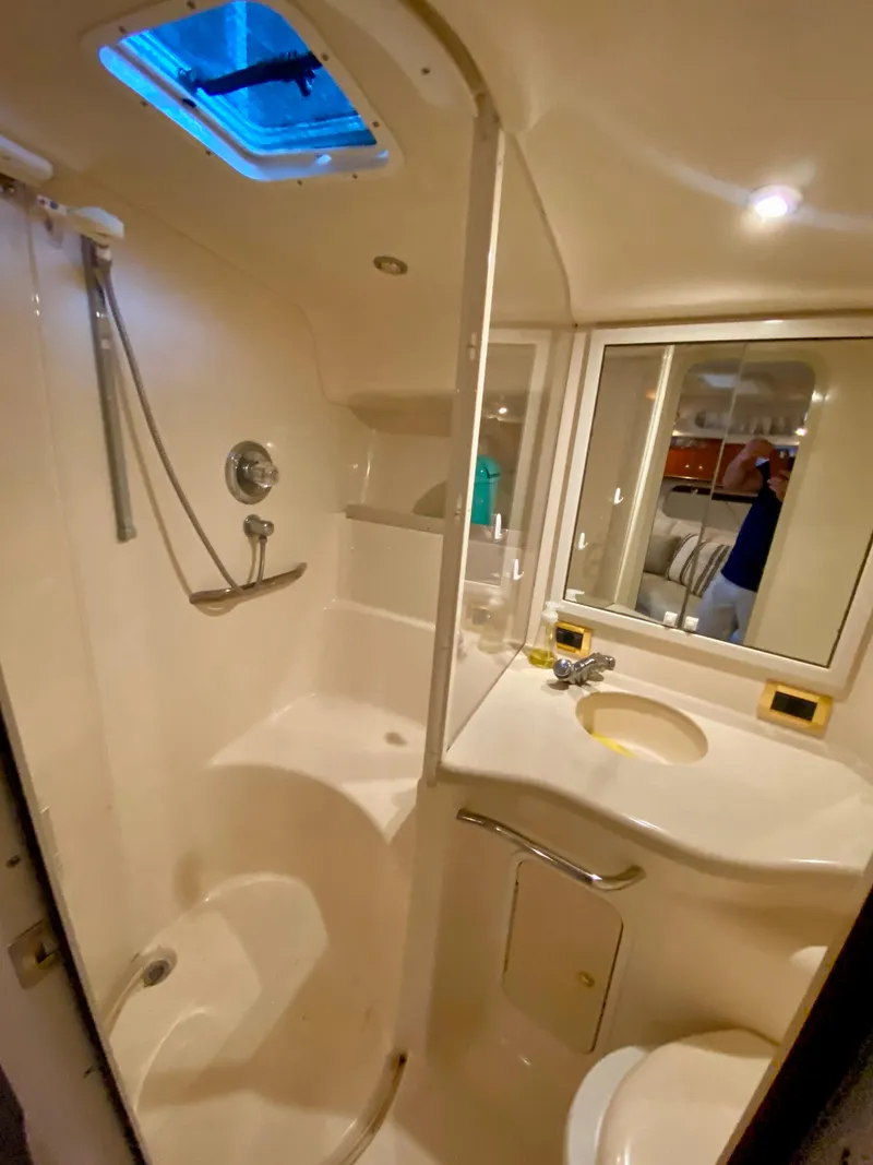 Slide: The Image of 1999 Sea Ray 400 Sundancer bathroom with shower, sink, and mirror. - 26