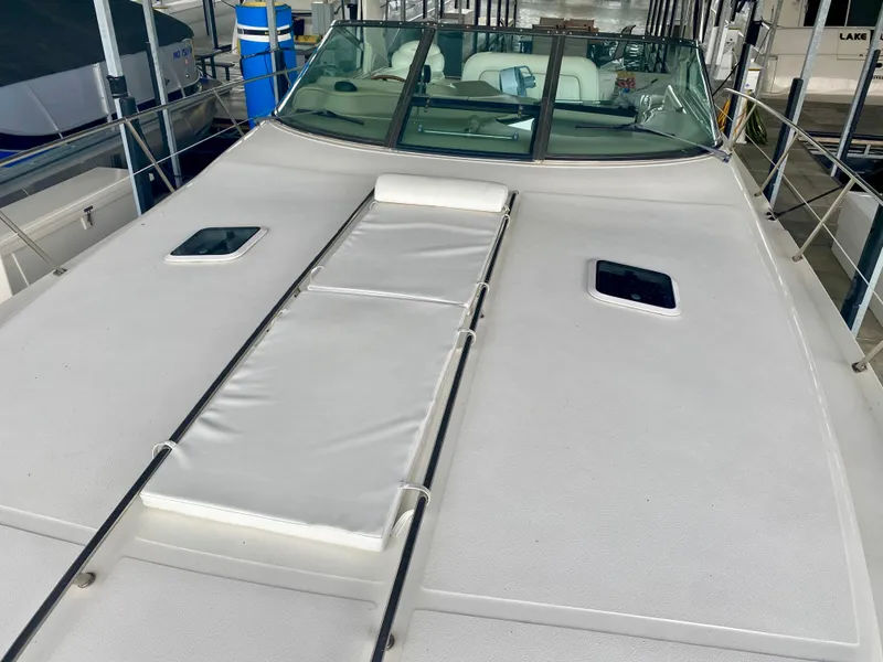 Slide: The Image of 1999 Sea Ray 400 Sundancer yacht deck with sunpad and hatches in marina. - 4