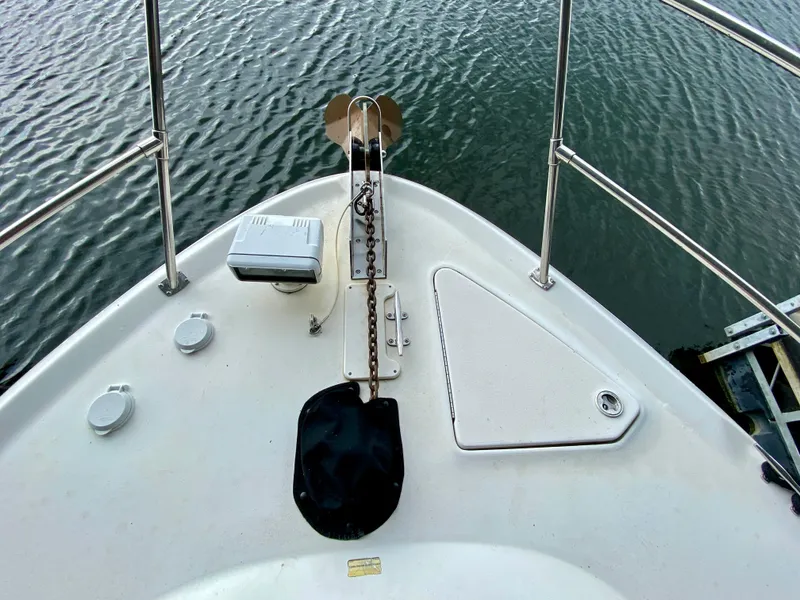 Slide: The Image of Bow of 1999 Sea Ray 400 Sundancer with anchor and railing on calm water. - 5