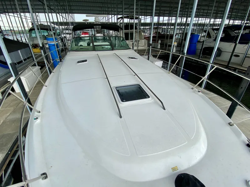 Slide: The Image of 1999 Sea Ray 400 Sundancer yacht docked in a marina, showcasing sleek deck design. - 6
