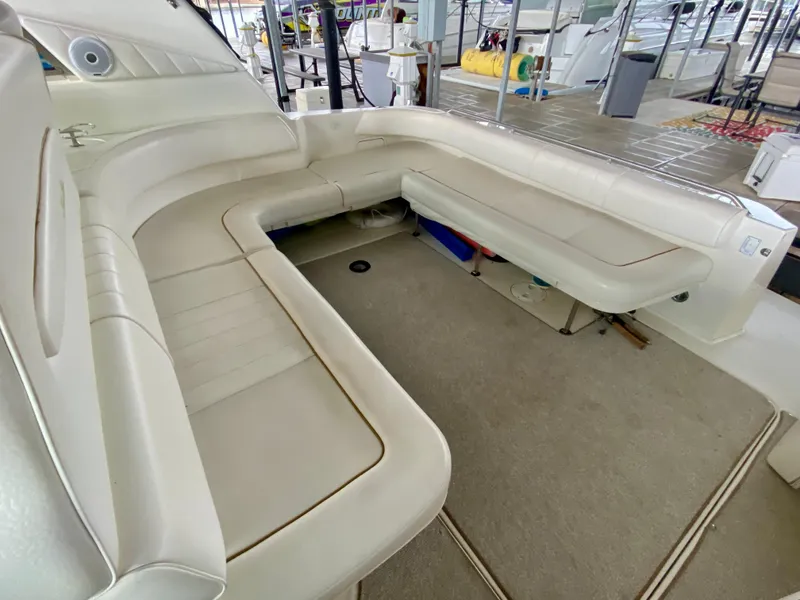 Slide: The Image of 1999 Sea Ray 400 Sundancer interior with spacious white seating and carpeted flooring. - 9