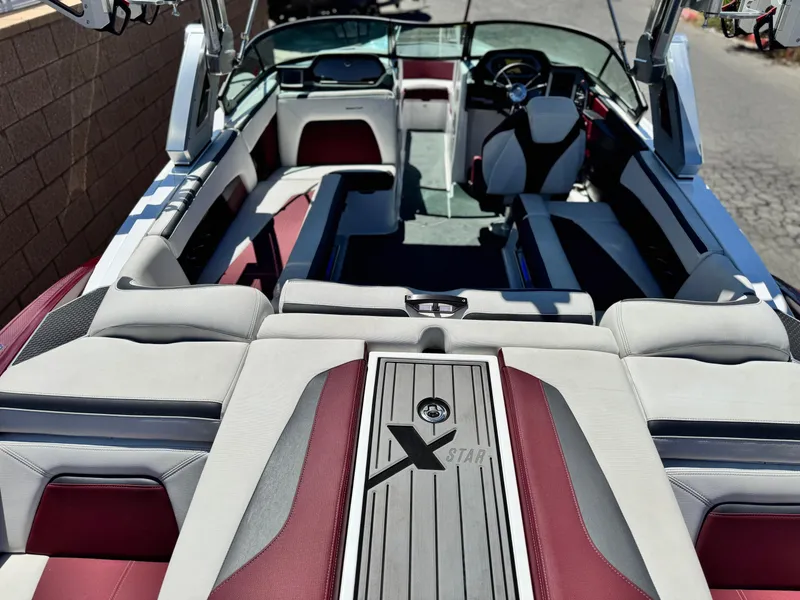 Slide: The Image of 2022 MasterCraft XStar S interior with red and white seating, sleek design, and modern dashboard. - 12