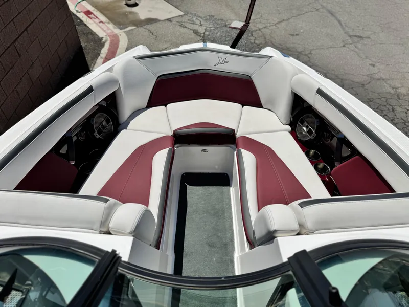 Slide: The Image of 2022 MasterCraft XStar S boat interior with white and maroon seating, showcasing luxury design. - 18
