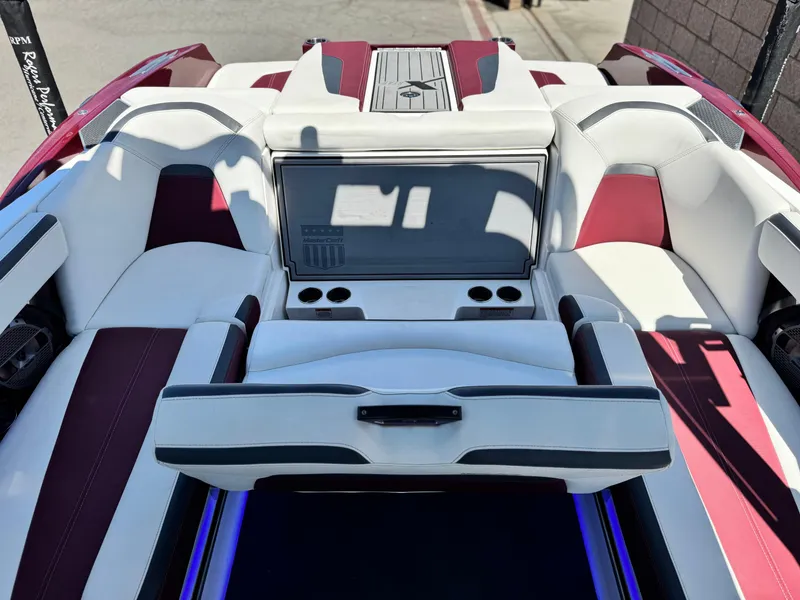 Slide: The Image of 2022 MasterCraft XStar S boat interior with white and red seating, cup holders, and sleek design. - 29