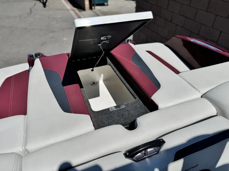 Slide: The Image of 2022 MasterCraft XStar S boat with open storage compartment and maroon-white seating. - 31