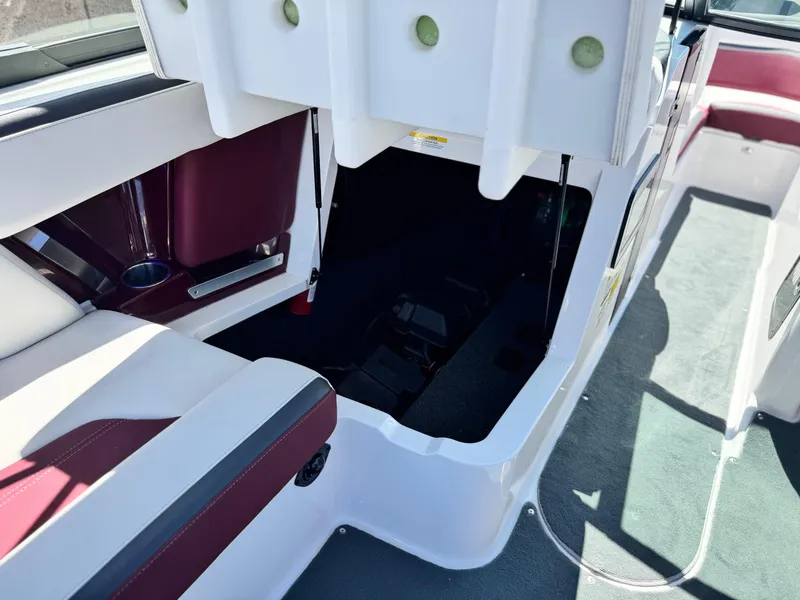 Slide: The Image of 2022 MasterCraft XStar S interior with open storage compartment and maroon seating. - 36
