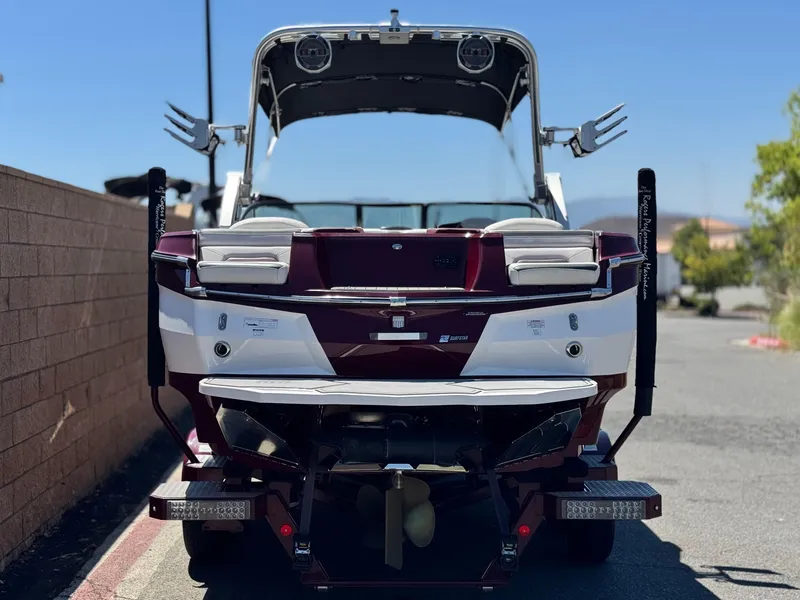 Slide: The Image of 2022 MasterCraft XStar S boat, rear view, parked outdoors on a sunny day. - 4