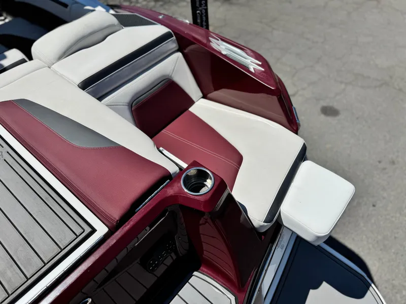 Slide: The Image of 2022 MasterCraft XStar S boat interior with red and white seating, cup holder, and sleek design. - 8
