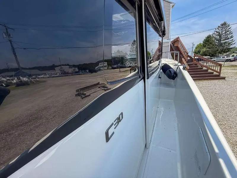 Slide: The Image of 2025 Navan C30 boat side view with reflection, docked outdoors. - 16