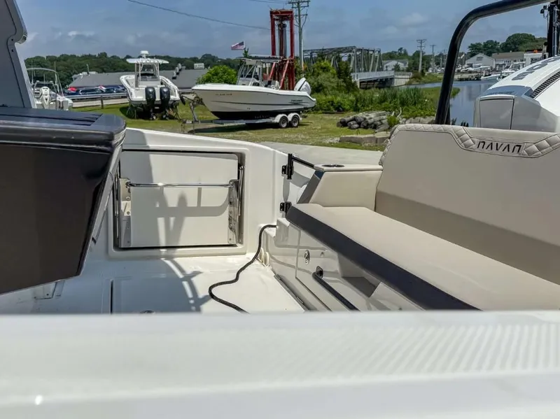 Slide: The Image of 2025 Navan C30 boat interior with seating and storage, docked near other boats. - 20