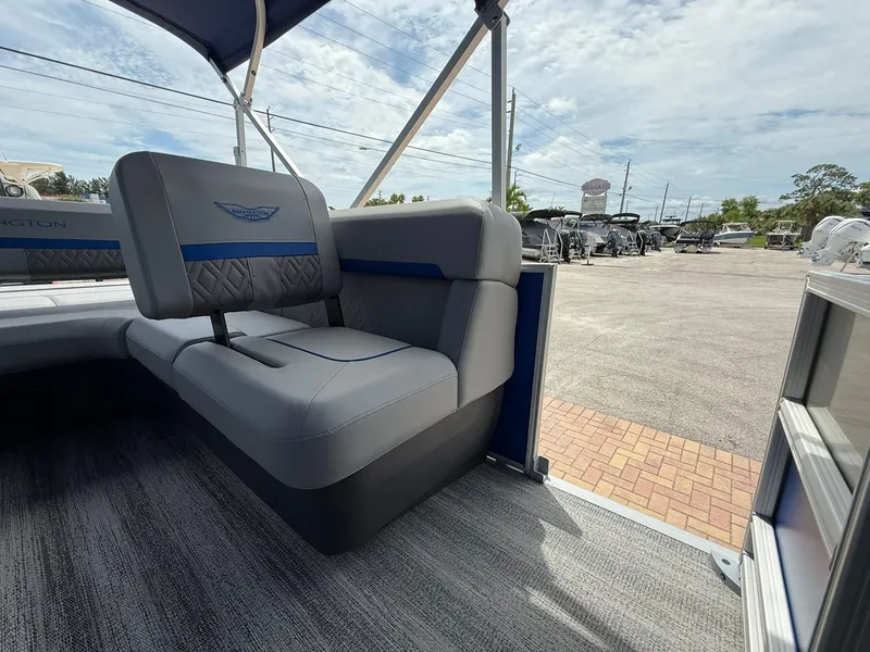 Slide: The Image of 2026 Bennington 22 MSB pontoon boat interior with gray and blue seating, outdoor showroom. - 11