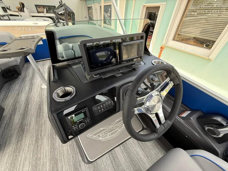 Slide: The Image of 2026 Bennington 22 MSB boat dashboard with steering wheel and navigation screens. - 15