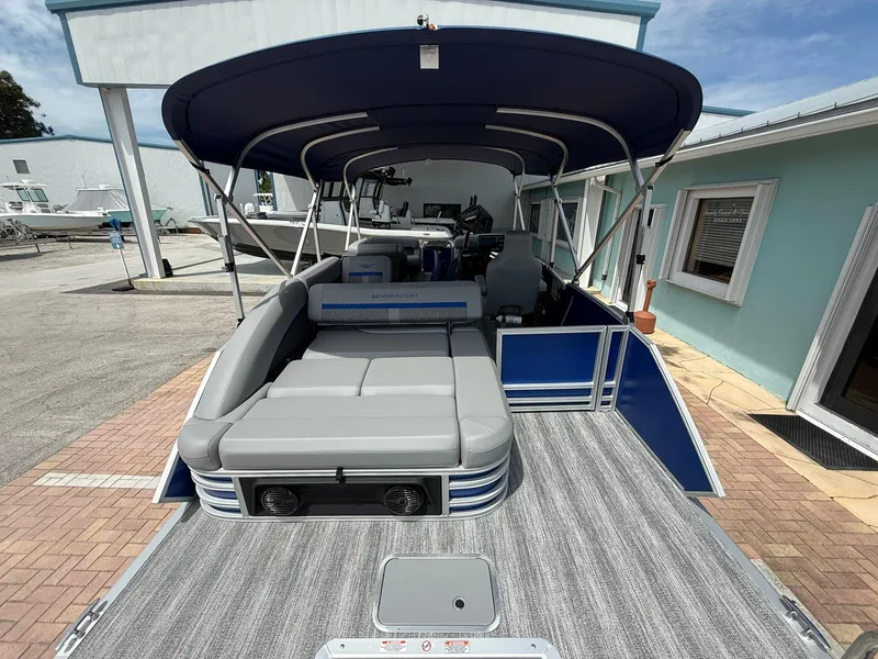 Slide: The Image of 2026 Bennington 22 MSB pontoon boat with spacious seating and canopy, docked at a marina. - 5
