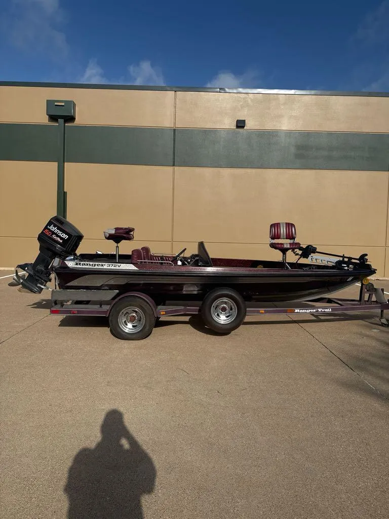Slide: The Image of 1995 Ranger 372V boat on trailer, parked outdoors, with Johnson outboard motor. - 0