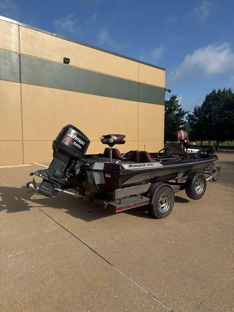 Slide: The Image of 1995 Ranger 372V boat with Johnson motor on trailer, parked outdoors. - 1
