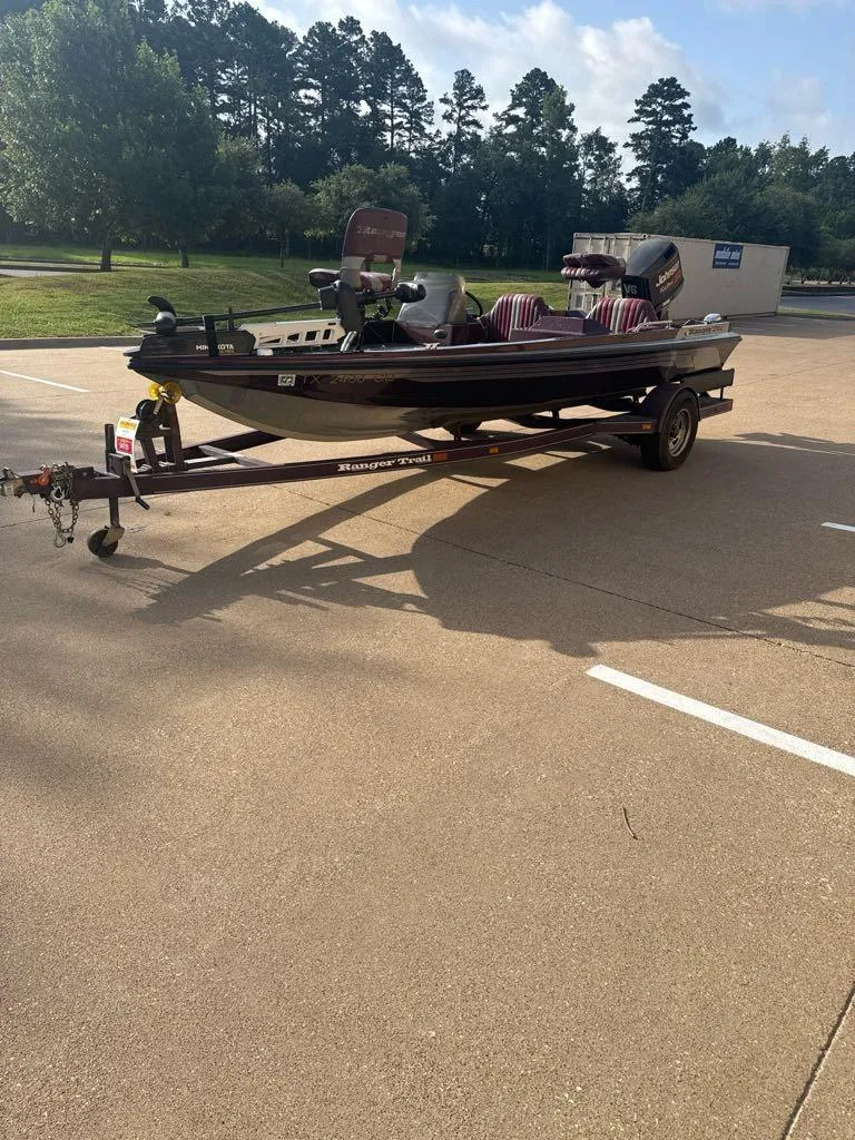 Slide: The Image of 1995 Ranger 372V boat on trailer in parking lot, surrounded by trees. - 10