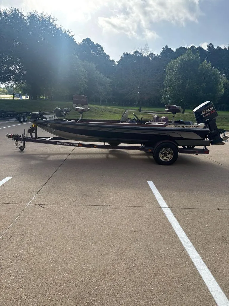Slide: The Image of 1995 Ranger 372V boat on trailer in parking lot, surrounded by trees. - 4