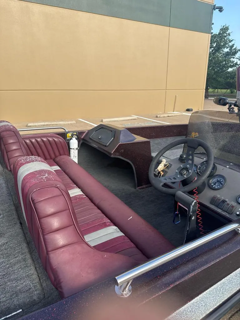 Slide: The Image of 1995 Ranger 372V boat interior with maroon seats and steering wheel, parked outdoors. - 9