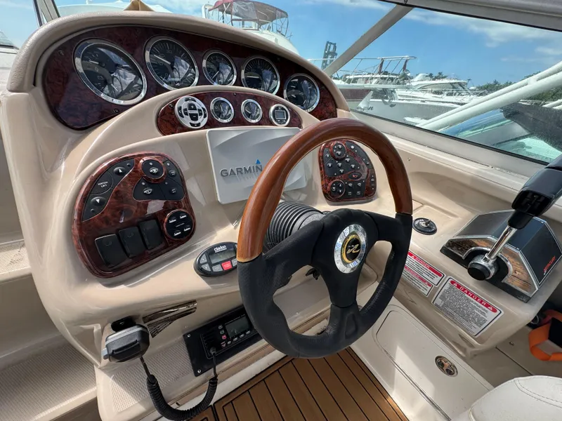 Slide: The Image of 2003 Sea Ray 280 Sundancer helm with Garmin navigation, wood accents, and control panel. - 11