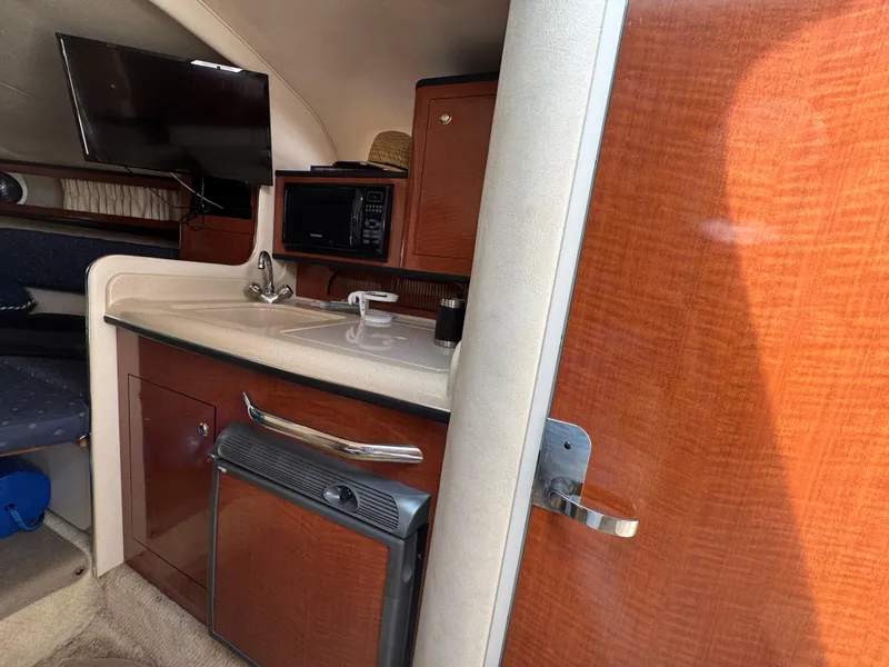 Slide: The Image of Interior of 2003 Sea Ray 280 Sundancer with kitchenette, TV, and microwave. - 13