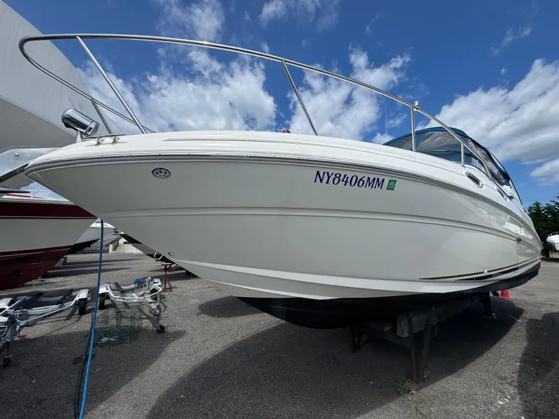 Slide: The Image of 2003 Sea Ray 280 Sundancer boat on display under a clear blue sky. - 2