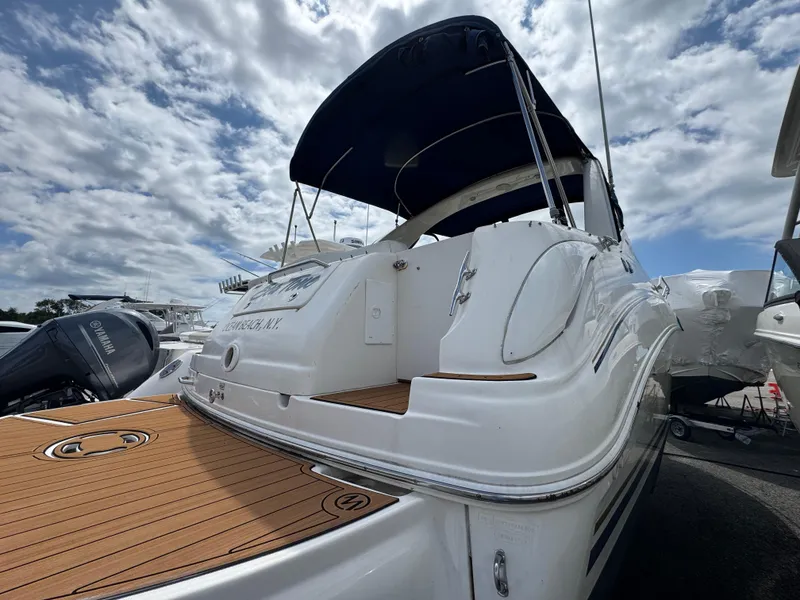 Slide: The Image of 2003 Sea Ray 280 Sundancer boat with wooden deck, docked under a cloudy sky. - 4