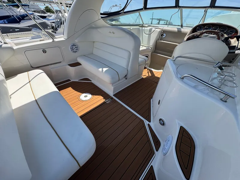 Slide: The Image of 2003 Sea Ray 280 Sundancer interior with white seating and wood flooring. - 5