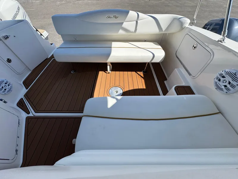 Slide: The Image of 2003 Sea Ray 280 Sundancer boat interior with white seating and wood flooring. - 6