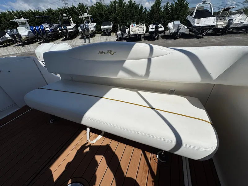 Slide: The Image of 2003 Sea Ray 280 Sundancer boat interior with white seating and wooden deck. - 8