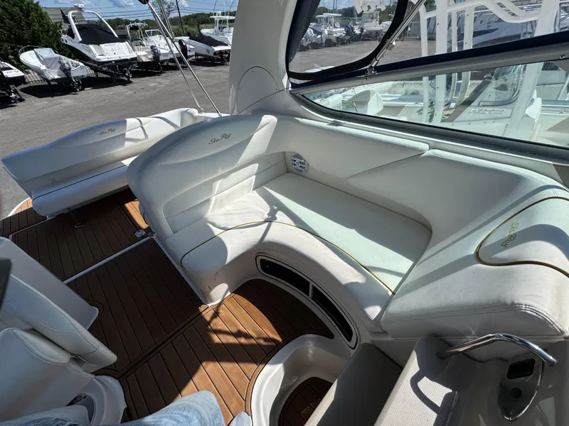 Slide: The Image of 2003 Sea Ray 280 Sundancer interior with white seating and wooden flooring. - 9
