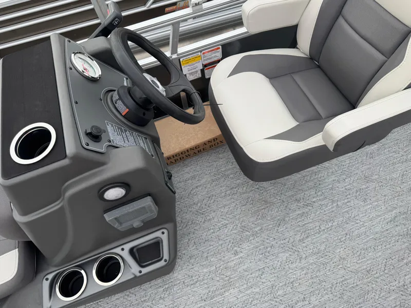 Slide: The Image of 2026 Sun Tracker Bass Buggy 16 XL boat interior with steering console and cushioned seat. - 13