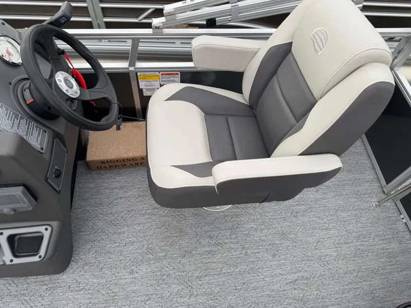 Slide: The Image of 2026 Sun Tracker Bass Buggy 16 XL boat interior with steering wheel and cushioned seat. - 19