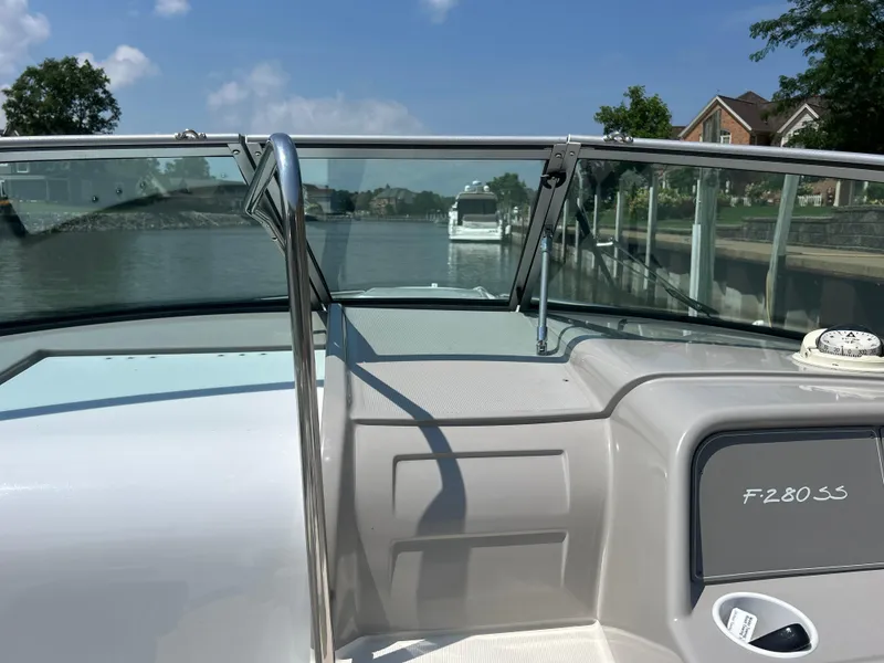 Slide: The Image of 2001 Formula 280 Sun Sport boat on a calm river, clear sky, and residential backdrop. - 29