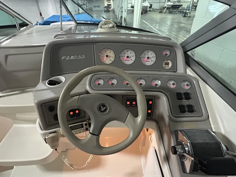 Slide: The Image of 2001 Formula 280 Sun Sport boat dashboard with steering wheel and gauges in a marina setting. - 36