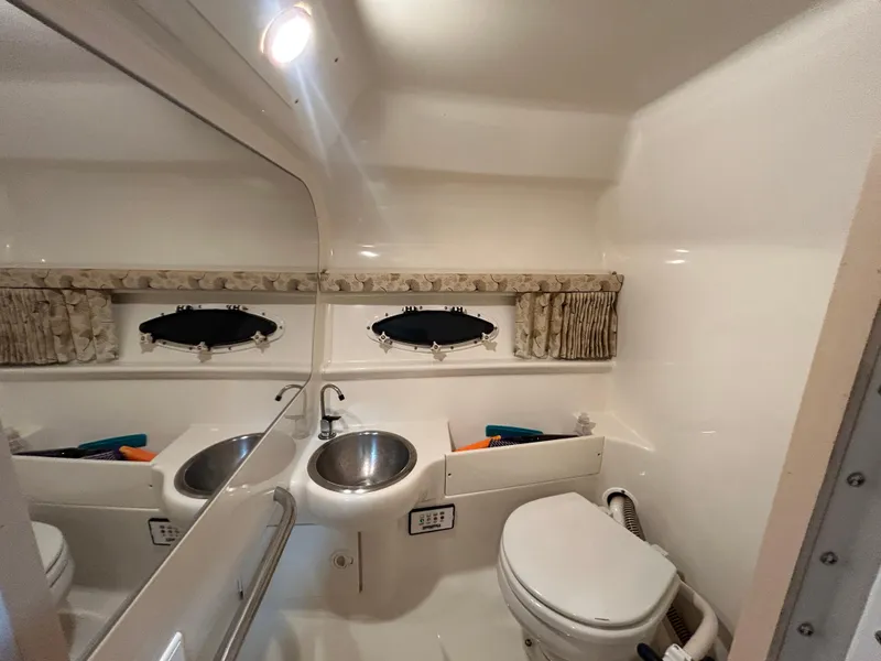 Slide: The Image of 2001 Formula 280 Sun Sport boat bathroom with sink, toilet, and porthole windows. - 48