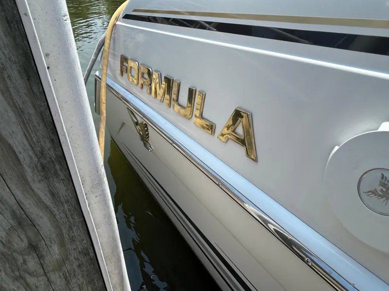 Slide: The Image of 2001 Formula 280 Sun Sport boat docked, showing gold lettering and sleek design. - 6