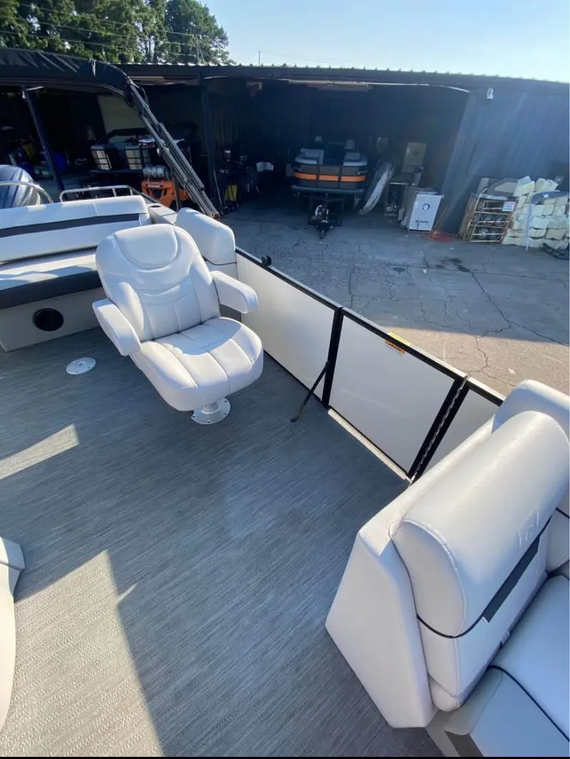 Slide: The Image of 2024 Godfrey SWEETWATER 2286 SFL boat interior with white seating and outdoor storage view. - 4