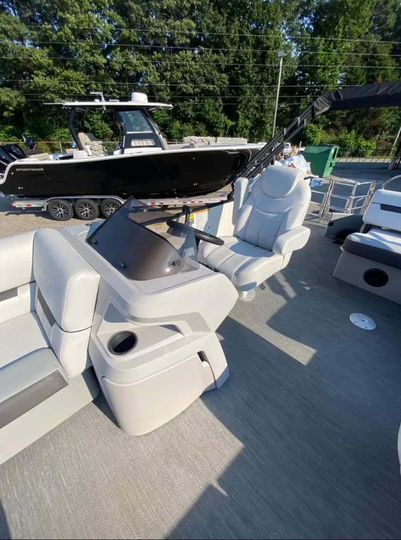 Slide: The Image of 2024 Godfrey SWEETWATER 2286 SFL boat interior with helm and seating, outdoors. - 5
