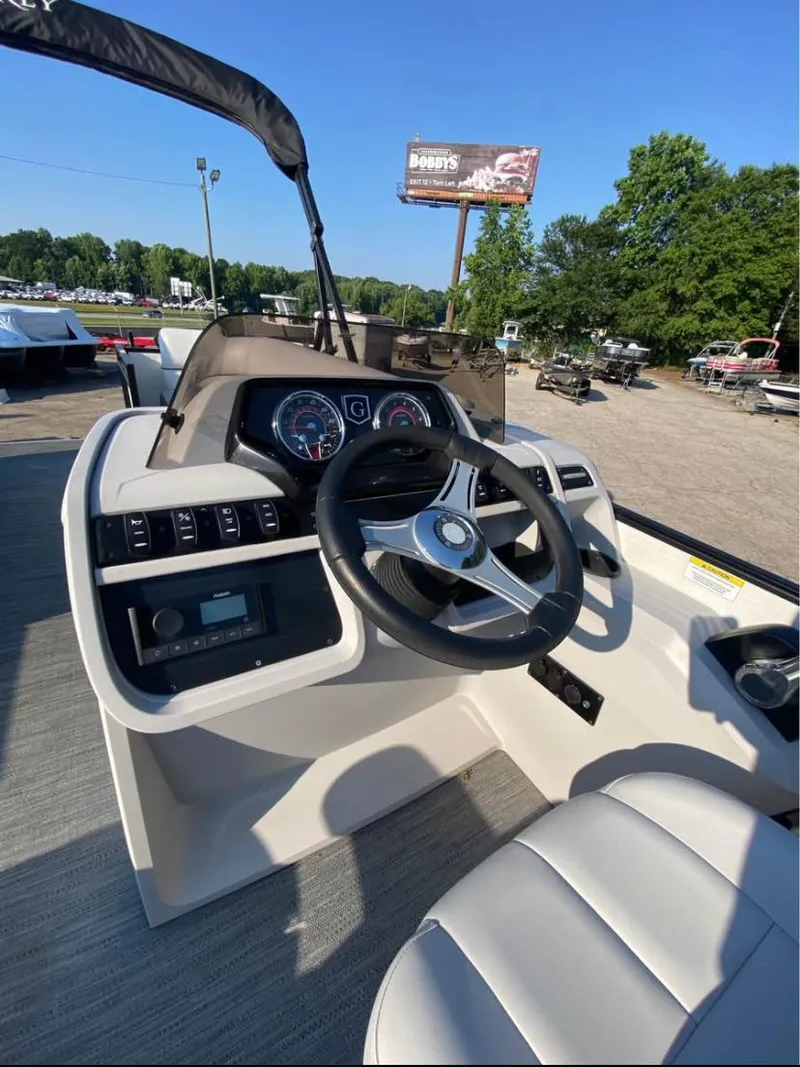 Slide: The Image of 2024 Godfrey SWEETWATER 2286 SFL boat dashboard with steering wheel and controls. - 6