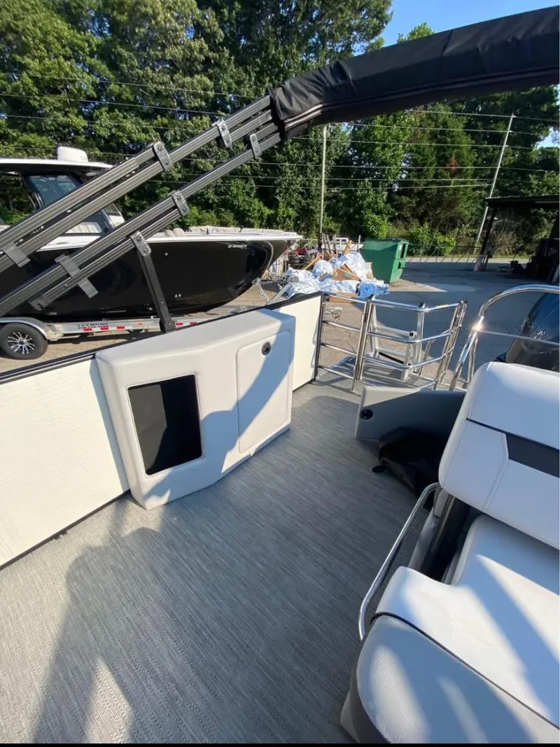 Slide: The Image of 2024 Godfrey SWEETWATER 2286 SFL boat interior with seating and ladder, outdoors. - 8