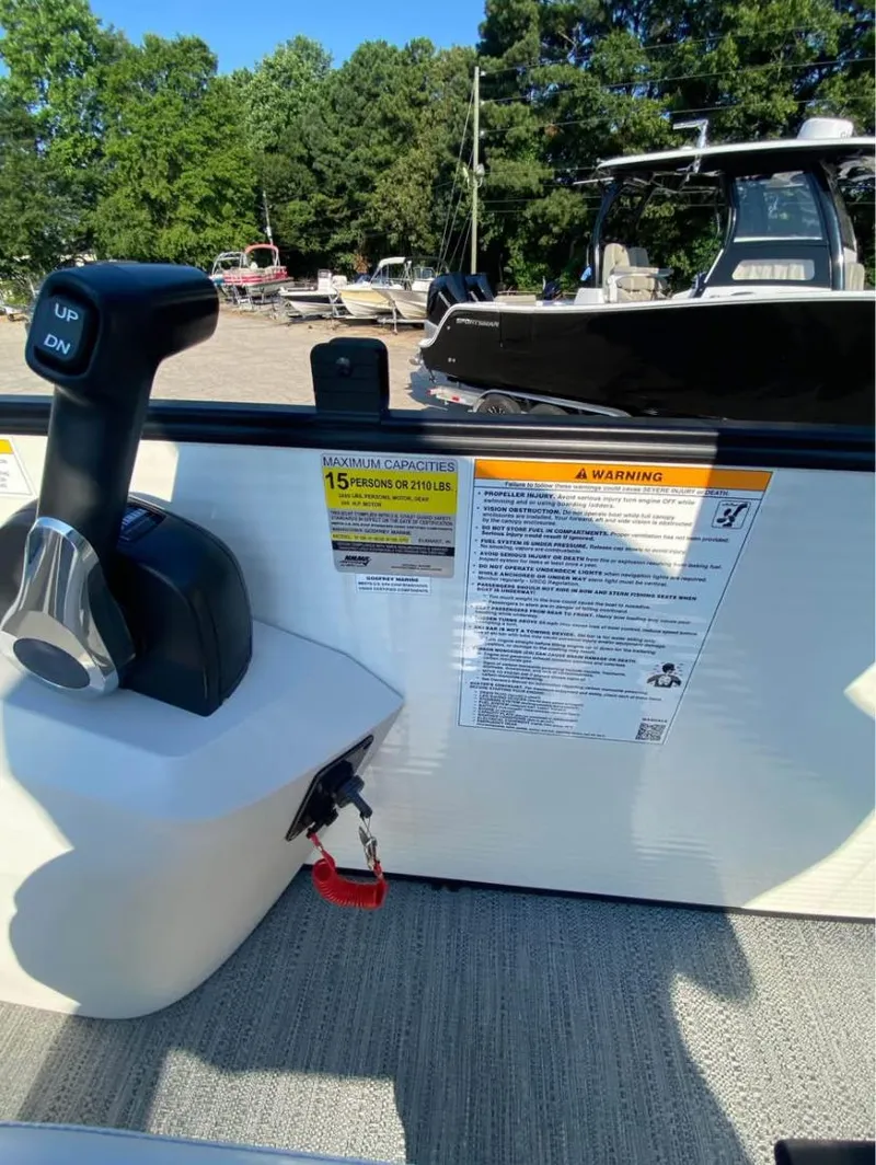 Slide: The Image of 2024 Godfrey SWEETWATER 2286 SFL boat controls with capacity warning label. - 9