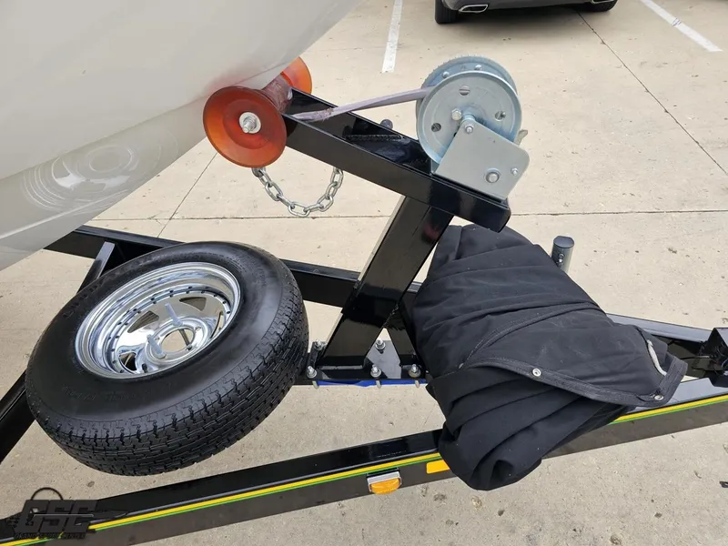 Slide: The Image of Trailer hitch and wheel of a 2005 Baja 23 Outlaw boat on pavement. - 15
