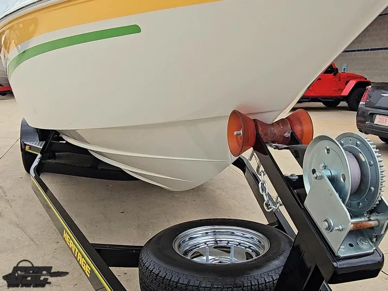 Slide: The Image of 2005 Baja 23 Outlaw boat on trailer, featuring vibrant yellow and green accents. - 16