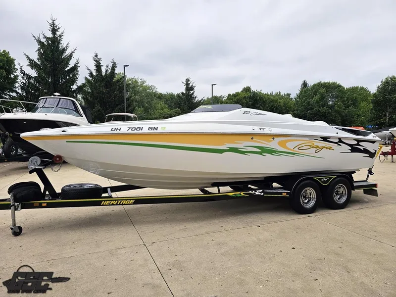 Slide: The Image of 2005 Baja 23 Outlaw speedboat on trailer, vibrant graphics, parked outdoors. - 24