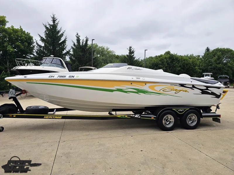 Slide: The Image of 2005 Baja 23 Outlaw speedboat on trailer, vibrant graphics, parked outdoors. - 25