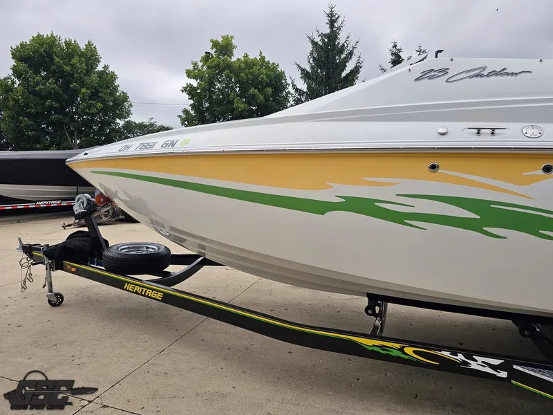 Slide: The Image of 2005 Baja 23 Outlaw boat on trailer with vibrant green and yellow graphics. - 28