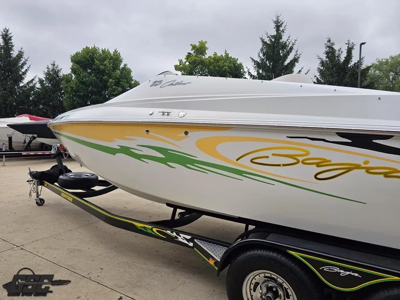 Slide: The Image of 2005 Baja 23 Outlaw boat with vibrant graphics on a trailer. - 31