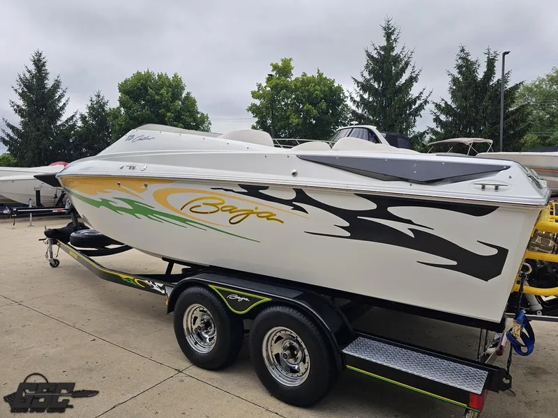 Slide: The Image of 2005 Baja 23 Outlaw speedboat on trailer, featuring vibrant graphics and sleek design. - 32